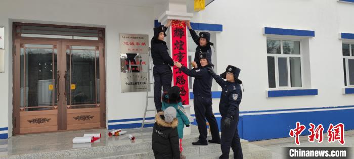 圖為恩和哈達邊境派出所民警貼對聯(lián)?！《骱凸_邊境派出所供圖
